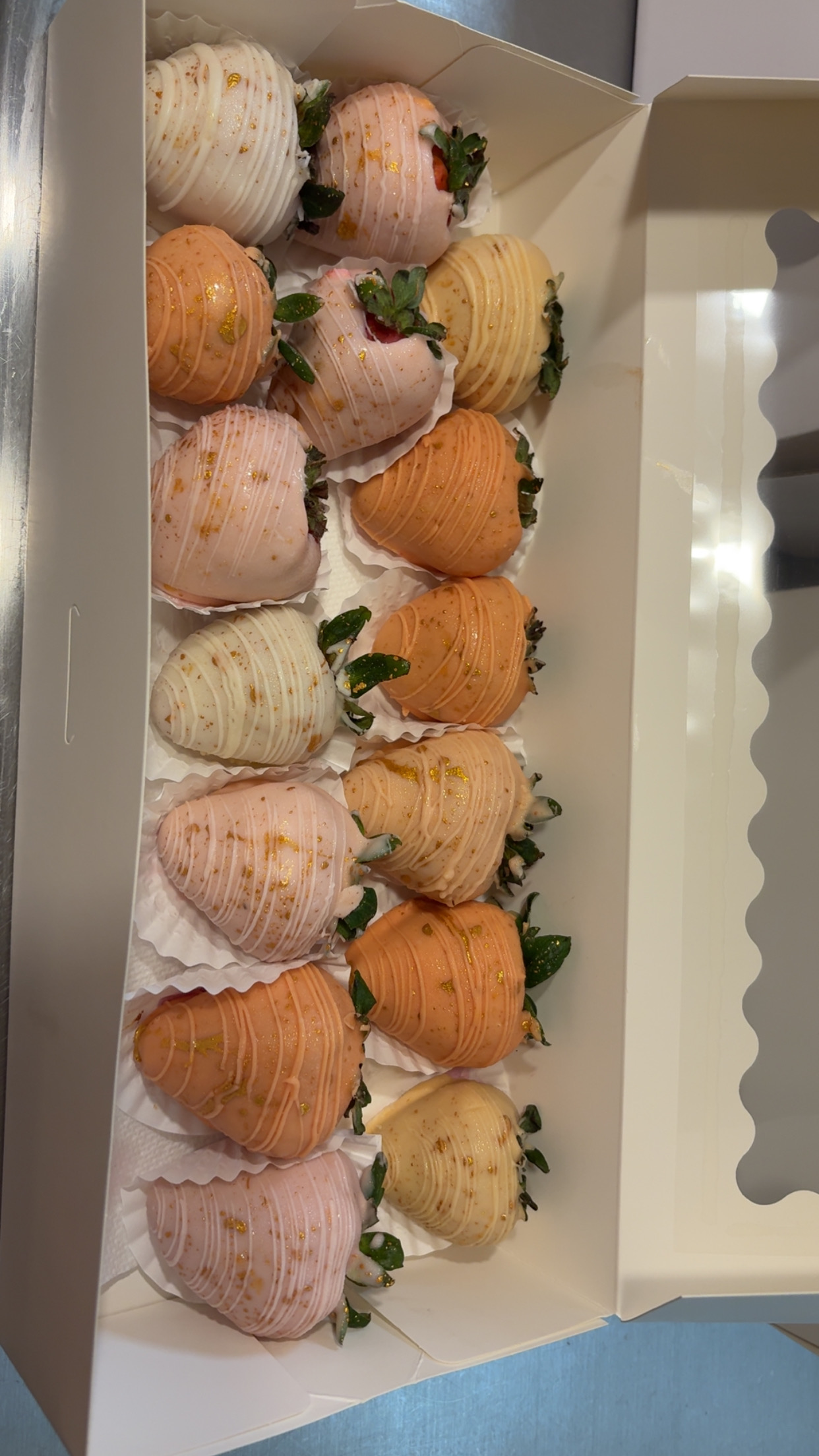 Box of premium chocolate-dipped strawberries in pink, peach, and cream